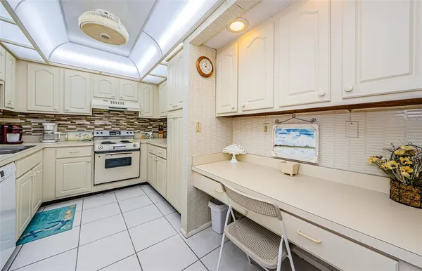 a kitchen with white cabinets and white appliances