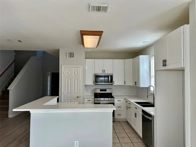 a kitchen with stainless steel appliances a stove refrigerator sink and cabinets