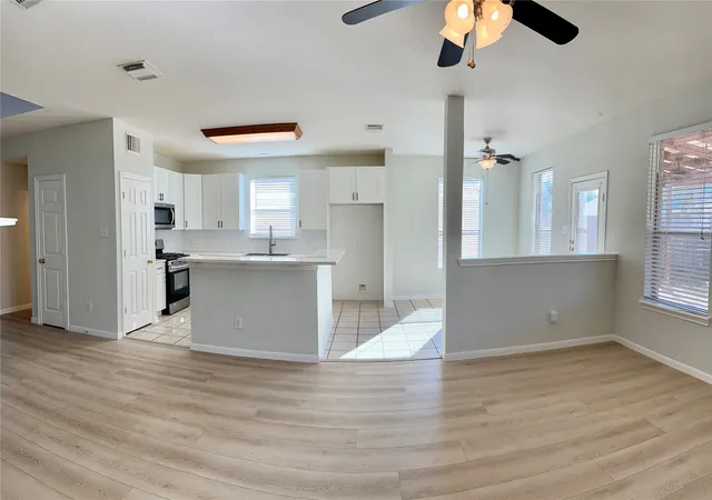 a view of kitchen with stainless steel appliances kitchen island a refrigerator sink and cabinets