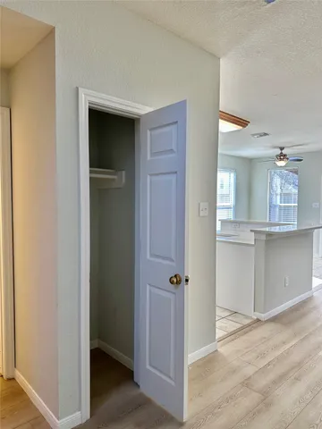 a view of a hallway with wooden floor and closet