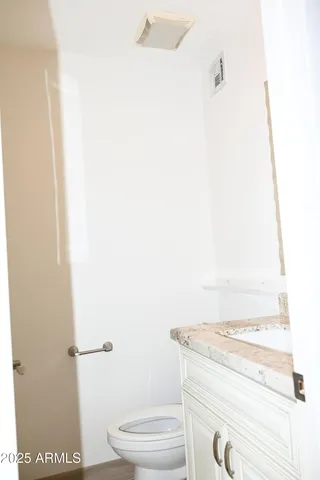 a bathroom with a granite countertop toilet and a sink