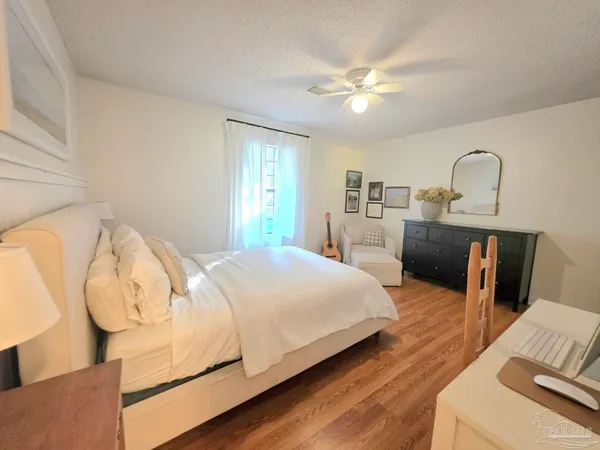 a spacious bedroom with a bed and wooden floor