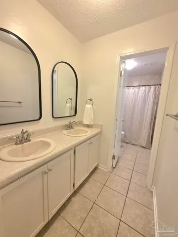 a spacious bathroom with a double vanity sink and mirror
