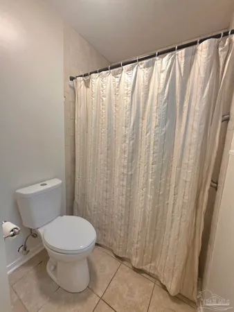 a white toilet sitting next to a shower curtain