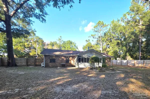 a front view of a house with a yard and tree