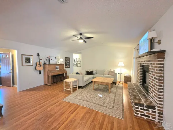a living room with furniture fireplace and wooden floor