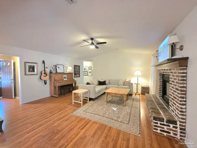 a living room with furniture fireplace and wooden floor