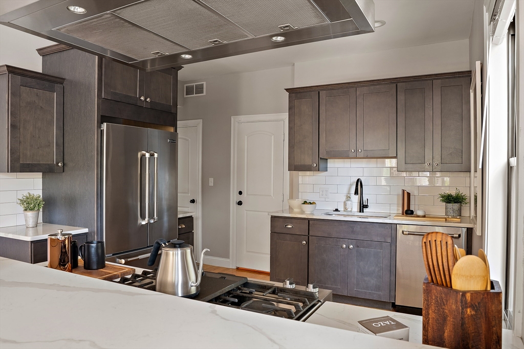 51 Dudley Street, Unit 2 Cambridge, MA 02140 - Photo 11 of 25 a kitchen with stainless steel appliances kitchen island granite countertop a sink refrigerator and cabinets