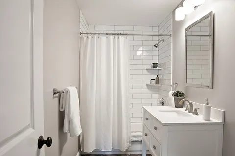 a bathroom with a shower a sink and a mirror