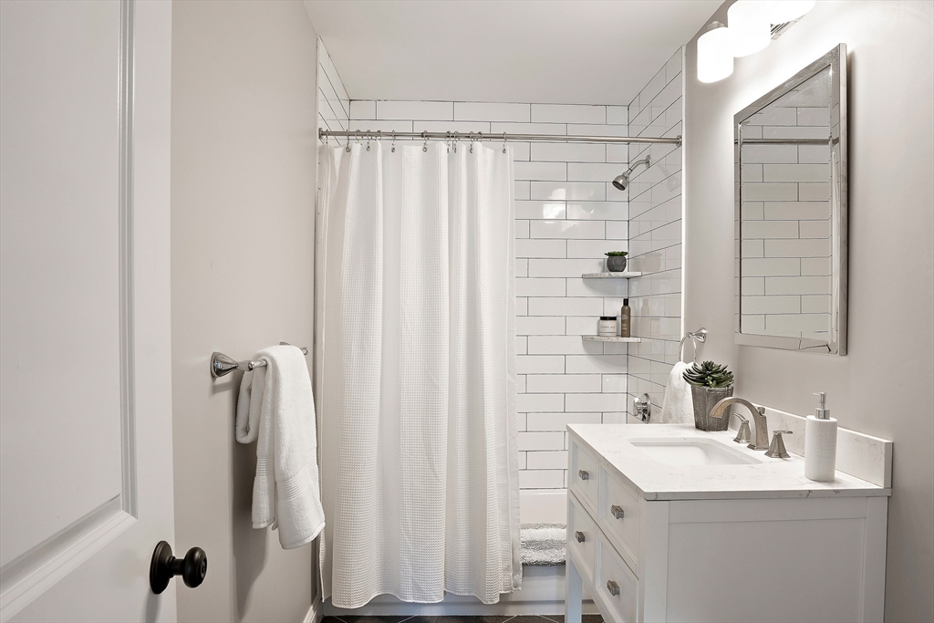 51 Dudley Street, Unit 2 Cambridge, MA 02140 - Photo 12 of 25 a bathroom with a shower a sink and a mirror
