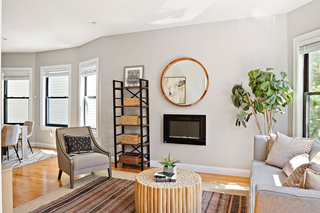 51 Dudley Street, Unit 2 Cambridge, MA 02140 - Photo 4 of 25 a living room with furniture a clock and a flat screen tv