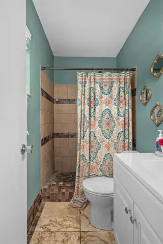 a bathroom with a sink a toilet and shower curtain