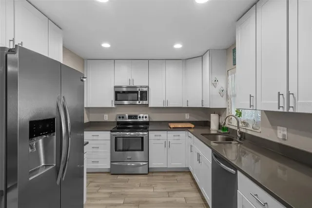 a kitchen with stainless steel appliances granite countertop a stove a refrigerator and a sink