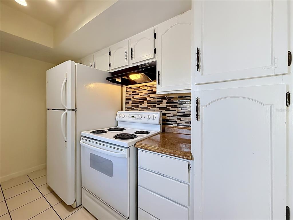 2636 Lemon Tree Lane, Unit 2636 Orlando, FL 32839 - Photo 20 of 51 a kitchen with white cabinets and white appliances
