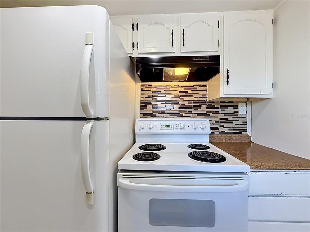 2636 Lemon Tree Lane, Unit 2636 Orlando, FL 32839 - Photo 21 of 51 a kitchen with a stove and white cabinets