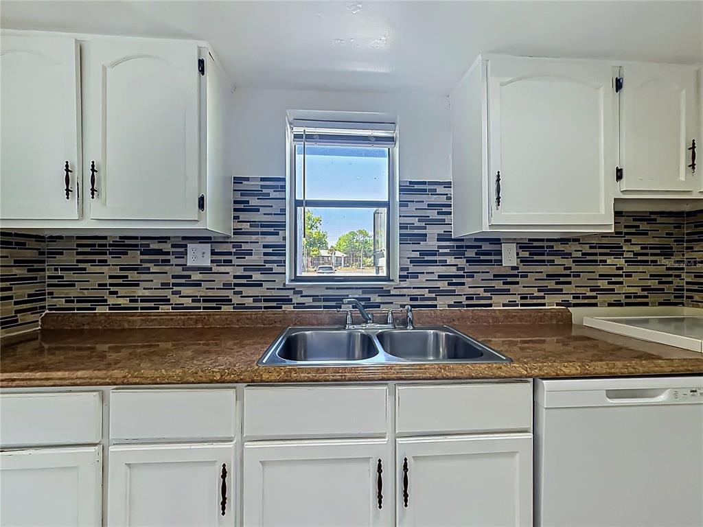2636 Lemon Tree Lane, Unit 2636 Orlando, FL 32839 - Photo 24 of 51 a kitchen with sink a window and cabinets