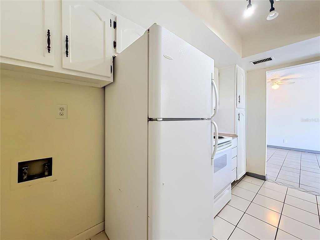 2636 Lemon Tree Lane, Unit 2636 Orlando, FL 32839 - Photo 26 of 51 a kitchen with a refrigerator and cabinets