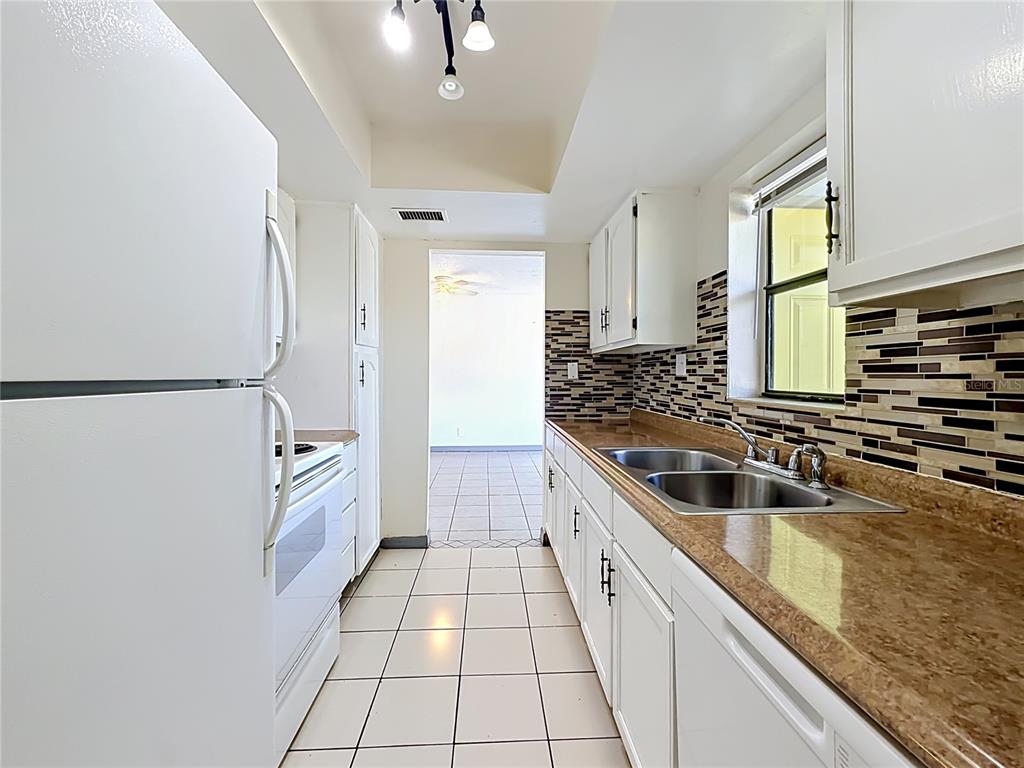 2636 Lemon Tree Lane, Unit 2636 Orlando, FL 32839 - Photo 27 of 51 a kitchen with granite countertop a sink a counter top space and cabinets