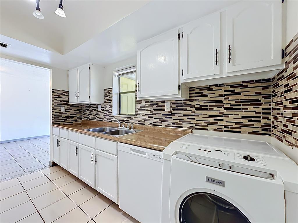 2636 Lemon Tree Lane, Unit 2636 Orlando, FL 32839 - Photo 28 of 51 a kitchen with granite countertop a sink a stove and cabinets