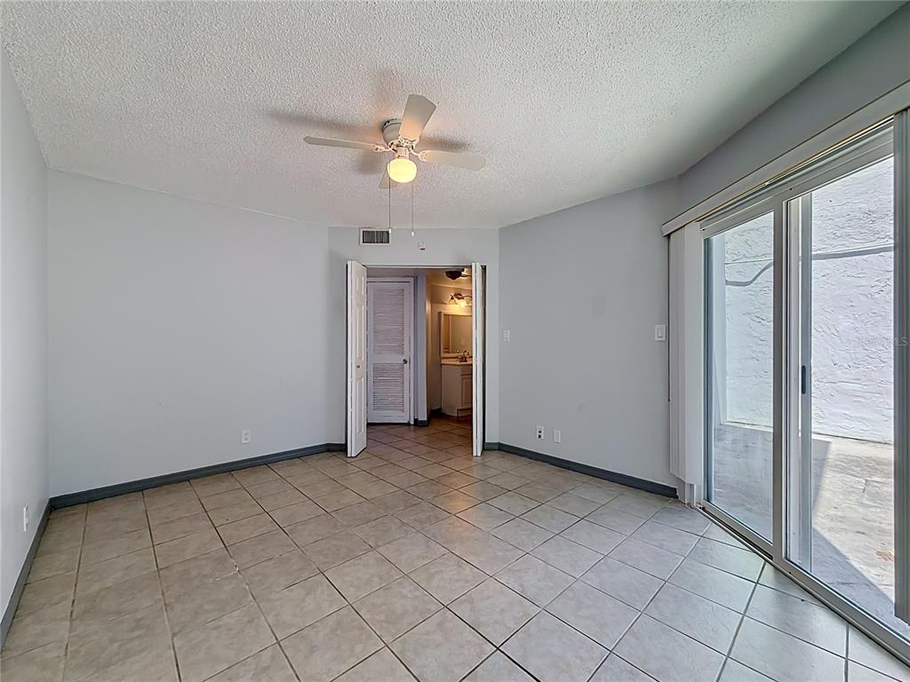2636 Lemon Tree Lane, Unit 2636 Orlando, FL 32839 - Photo 32 of 51 an empty room with chandelier fan and windows