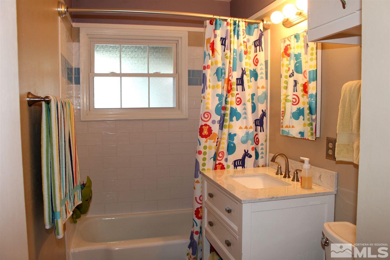 1421 Samuel Way Reno, NV 89509 - Photo 17 of 25 a bathroom with a sink vanity mirror and shower