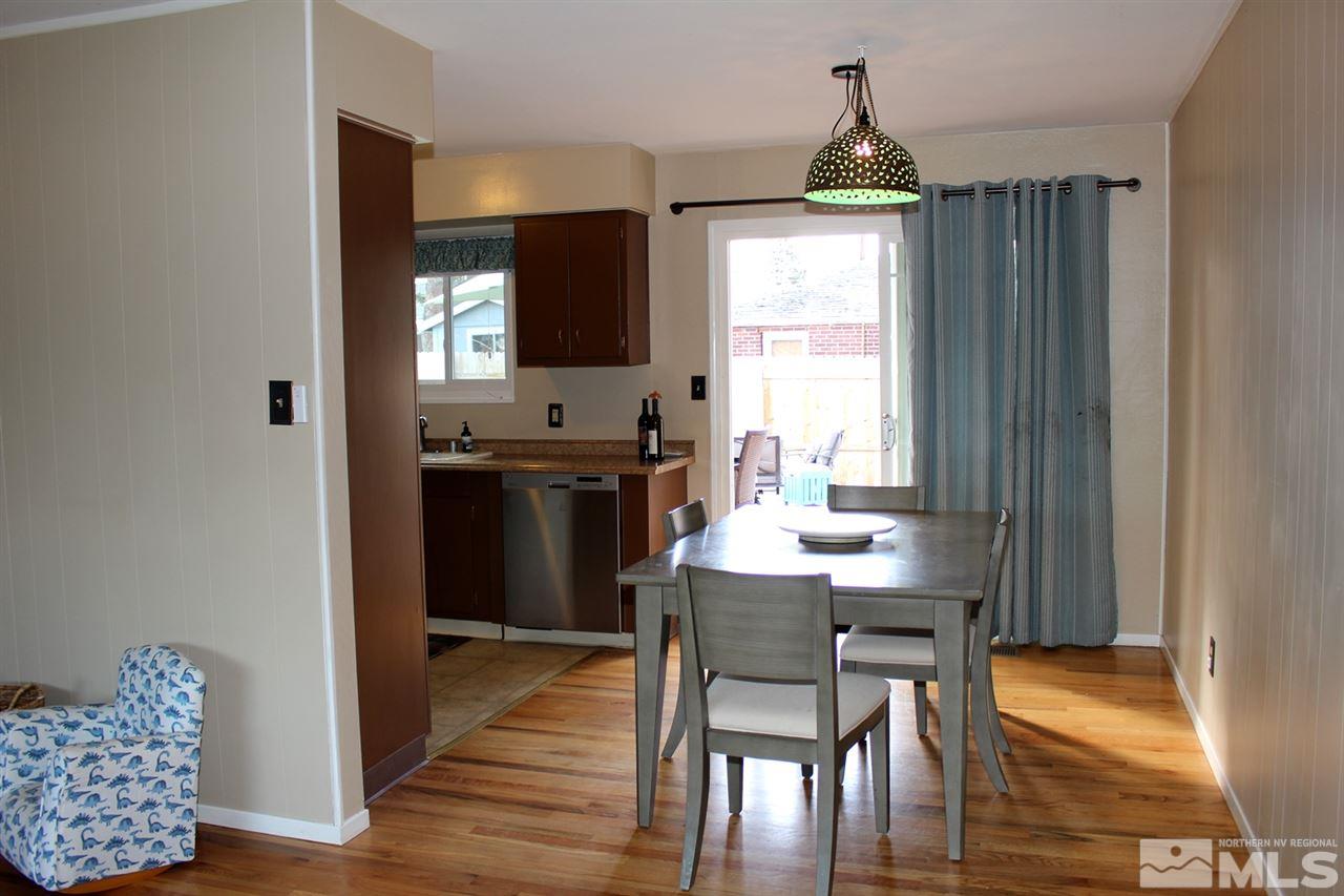1421 Samuel Way Reno, NV 89509 - Photo 6 of 25 a kitchen with granite countertop a stove a sink and a dining table with chairs