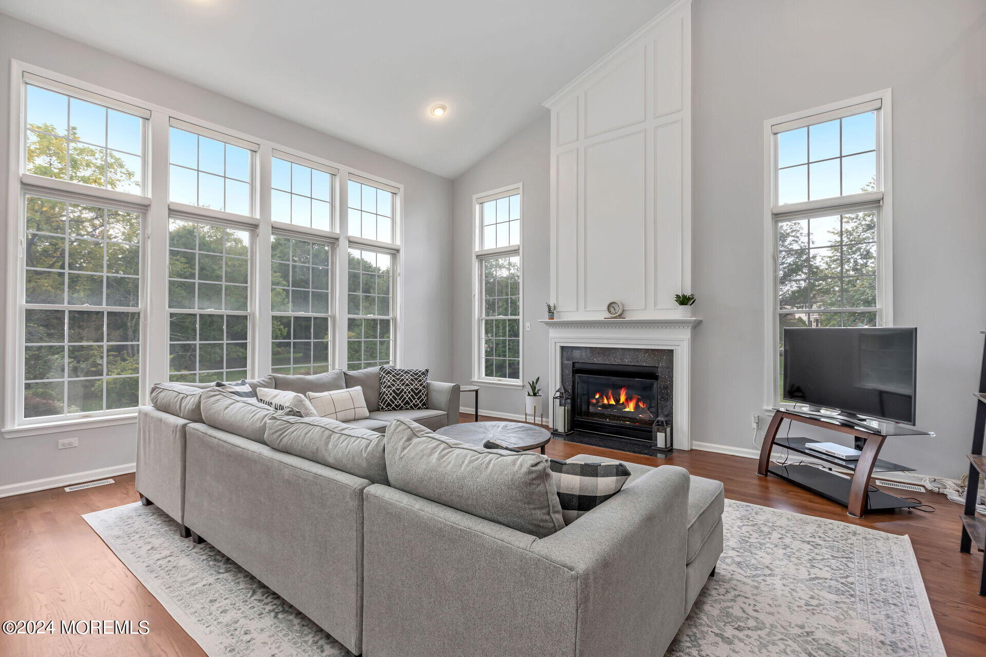 20 Crape Myrtle Drive Holmdel, NJ 07733 - Photo 14 of 53 a living room with furniture a fireplace and a floor to ceiling window