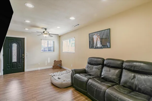 a living room with furniture and a wooden floor