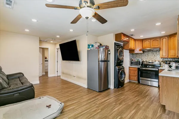 a living room with stainless steel appliances furniture or kitchen view and a refrigerator
