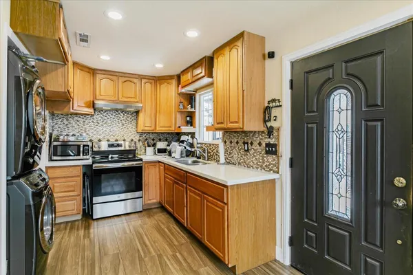 a kitchen with stainless steel appliances granite countertop a stove a sink and a refrigerator