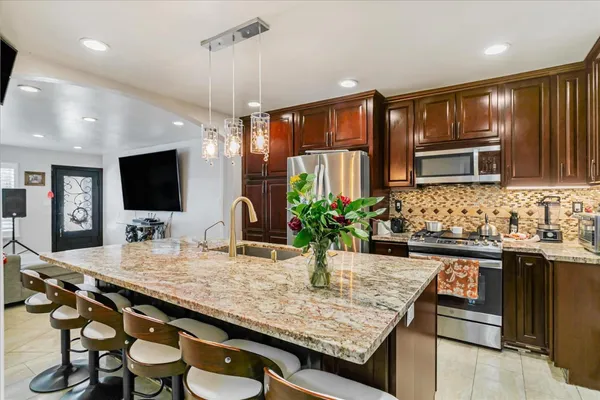 a kitchen with granite countertop a sink and a wooden floor