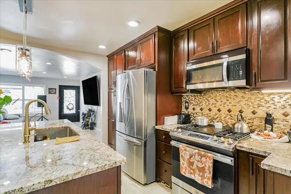 a kitchen with granite countertop stainless steel appliances and wooden cabinets