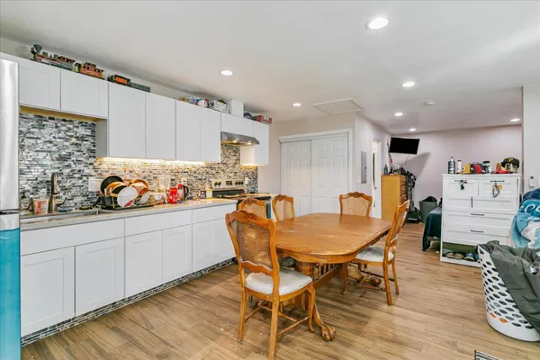 a kitchen with granite countertop a dining table chairs and white cabinets
