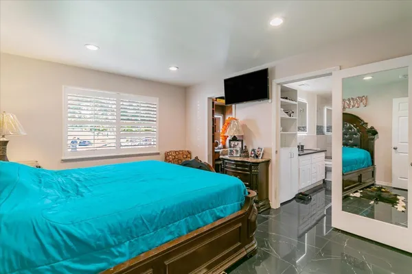 a bed room with a bed television and a window