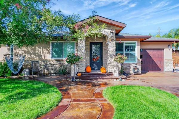 a front view of a house with garden and sitting area