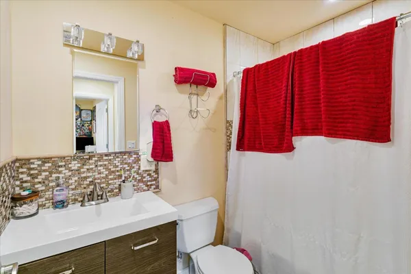 a bathroom with a sink vanity mirror and toilet