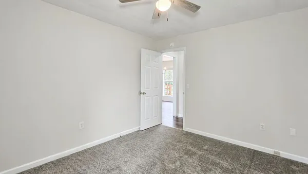 an empty room with a chandelier fan