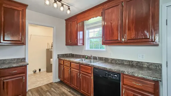 a kitchen with granite countertop cabinets sink and window