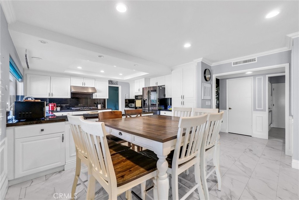 1417 West James Way Anaheim, CA 92801 - Photo 12 of 40 a kitchen with stainless steel appliances kitchen island granite countertop a table chairs and a refrigerator