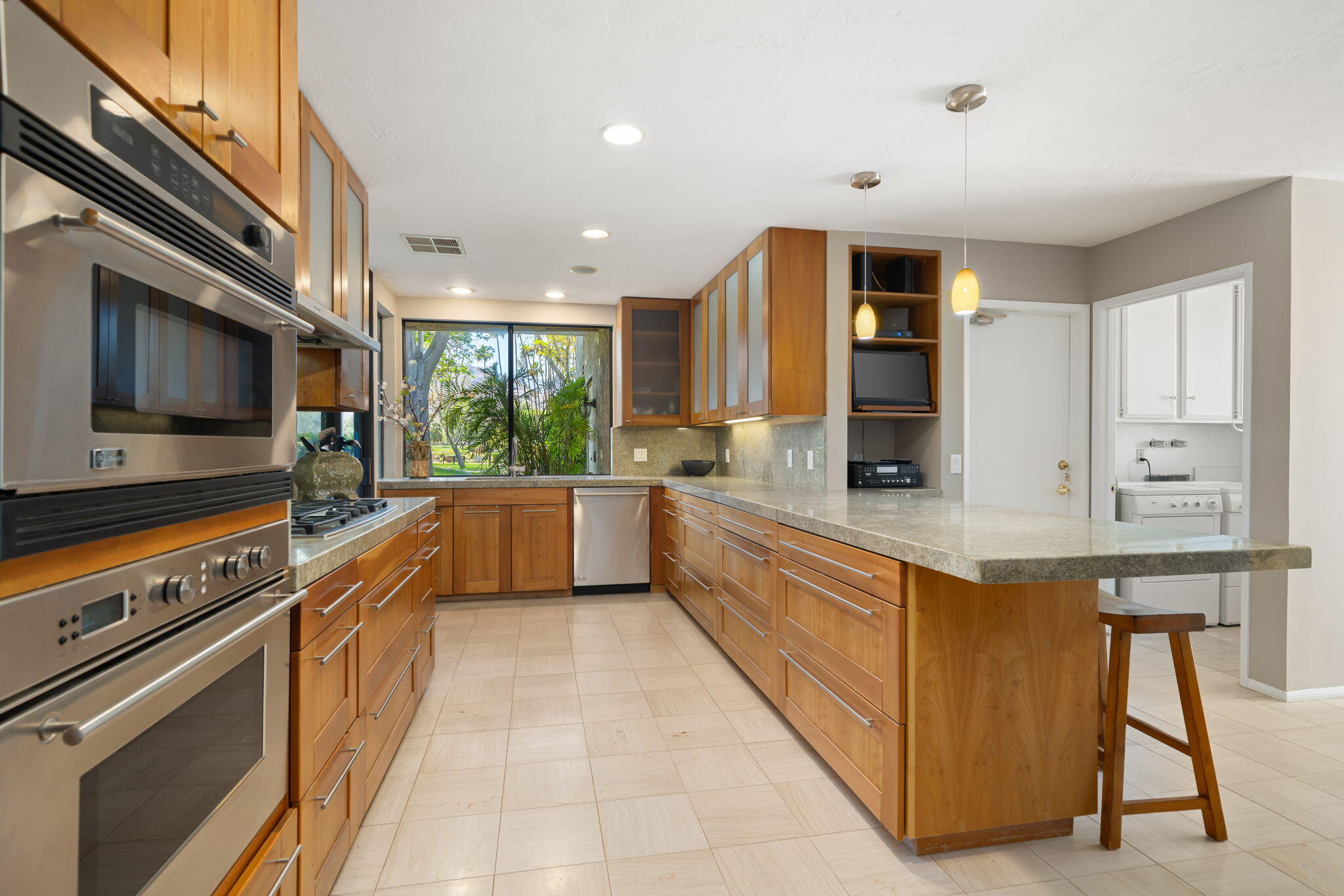 26 Stanford Drive Rancho Mirage, CA 92270 - Photo 11 of 39 a kitchen with stainless steel appliances kitchen island granite countertop a stove a sink and a microwave
