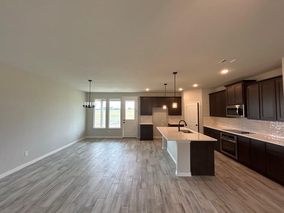 8779 County Road 623 Blue Ridge, TX 75424 - Photo 6 of 12 a large kitchen with kitchen island a sink dishwasher a dining table and chairs with wooden floor