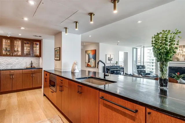 a large kitchen with stainless steel appliances a large counter top a stove and a sink