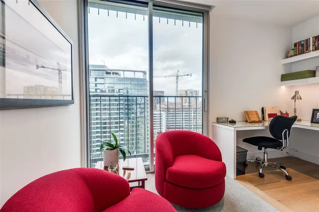 a view of a workspace with furniture and a window