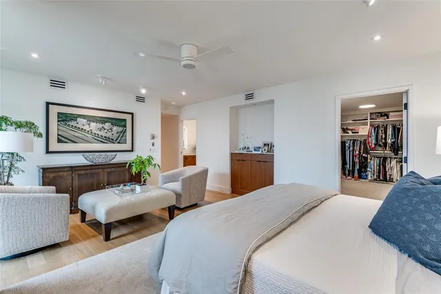 a spacious bedroom with a bed a couch and a bookshelf