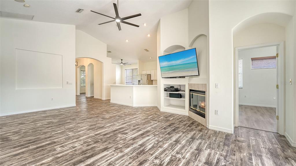 6213 Willet Court Lakewood Ranch, FL 34202 - Photo 11 of 74 a view of a kitchen with wooden floor a ceiling fan and refrigerator in a kitchen