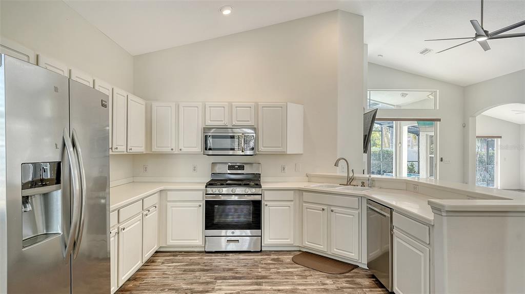 6213 Willet Court Lakewood Ranch, FL 34202 - Photo 14 of 74 a kitchen with stainless steel appliances a sink cabinets and a window
