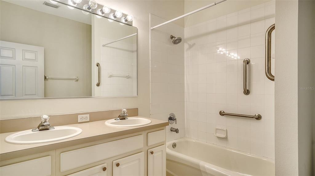6213 Willet Court Lakewood Ranch, FL 34202 - Photo 26 of 74 a bathroom with a granite countertop sink a mirror a shower and a bathtub