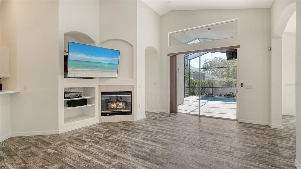6213 Willet Court Lakewood Ranch, FL 34202 - Photo 10 of 74 a view of a livingroom with a flat screen tv wooden floor and a fireplace