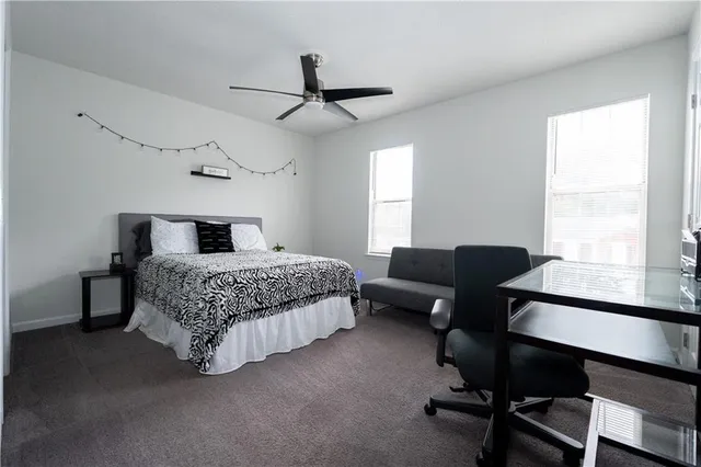 a bedroom with a bed window and a desk
