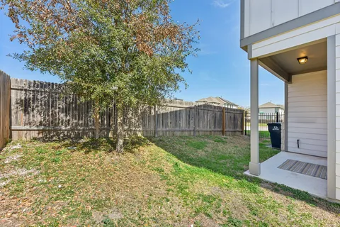 a view of backyard with wooden fence